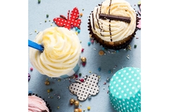 Image Colorful cupcakes with creamy frosting, sprinkles, and decorative paper butterflies on a light blue background